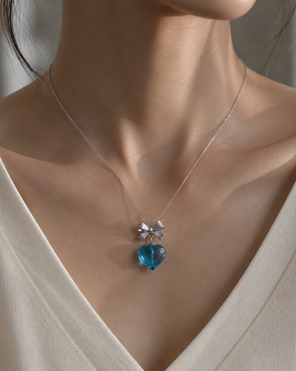 Model wearing the Blue Valentine Bow Necklace aquamarine heart pendant